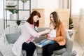 A portrait of an Caucasian female pediatrician using stethoscope examining a baby girl in the mother hands Royalty Free Stock Photo