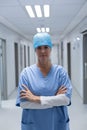 Female surgeon standing with arms crossed in the corridor of hospital Royalty Free Stock Photo