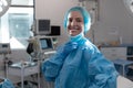 Portrait of caucasian female surgeon standing in operating theatre wearing face mask Royalty Free Stock Photo