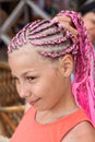 Portrait of caucasian girl with pink dreadlocks hairstyle, holding her plait with hand