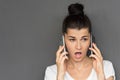 Portrait of Caucasian gossip woman with dark bun hair wearing white casual T-shirt talking over smartphone with her friend, having