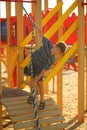 Portrait of a caucasian happy boy playing at the sunlit outdoor playground