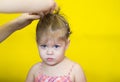 Portrait of caucasian little girl of two year old with serious look whom is straighten hair on the yellow background Royalty Free Stock Photo