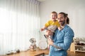 Portrait of Caucasian loving father hold baby boy child in living room. Happy family, attractive caring young dadd carry his