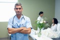 Male doctor standing with arms crossed in the ward at hospital Royalty Free Stock Photo