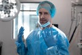 Portrait of caucasian male doctor standing in operating theatre wearing face mask Royalty Free Stock Photo