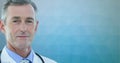 Portrait of caucasian male senior doctor smiling against textured gradient blue background Royalty Free Stock Photo