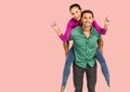 Portrait of caucasian man giving a piggy back ride to his wife against copy space on pink background Royalty Free Stock Photo