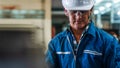 Portrait of caucasian man industrial worker or labor in blue factory uniform with white safty helmet in factory metal workshop Royalty Free Stock Photo