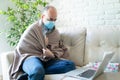 Man with covid19 and mask looking at laptop