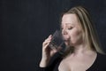 portrait caucasian middel aged woman in black blouse drinking water in the Dark room,healthy lifstile concept