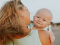 Portrait of Caucasian mother with blond hair and baby son spending time on beach. Mom holding infant boy. Summer vacation. Family Royalty Free Stock Photo