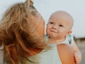 Portrait of Caucasian mother with blond hair and baby son spending time on beach. Mom holding infant boy. Summer vacation. Family Royalty Free Stock Photo