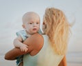 Portrait of Caucasian mother with blond hair and baby son spending time on beach. Summer vacation in Asia. Family relationships. Royalty Free Stock Photo