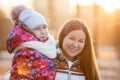 Portrait of Caucasian mother with child at winter, a frosty evening, sunshine, sunset