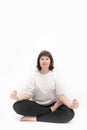 Portrait of caucasian plus size woman on white background practicing yoga. Ardha-padmasana, half lotus pose. Vertical framer. Copy