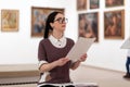 Portrait of caucasian pretty young woman wearing glasses learning educational brochure. Defocused pictures in background Royalty Free Stock Photo