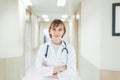 Portrait of caucasian senior woman doctor posing with arms crossed with stethoscope in hospital Royalty Free Stock Photo