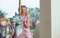 Portrait of Caucasian senior woman smile and ride horse on Carousel at amusement park with happy mood Royalty Free Stock Photo