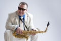 Portrait of Caucasian Smiling Man Posing With Saxophone and Wearing Sunglasses. Royalty Free Stock Photo