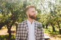 Portrait of Caucasian stylish bearded groom in vintage suit posing outdoors in sunny weather. Handsome man with beard in Royalty Free Stock Photo