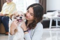Portrait of Caucasian teenage girl playing with shih tzu puppy dog at home. Young beautiful woman sitting on floor, smiling, Royalty Free Stock Photo