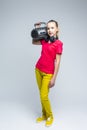 Portrait of Caucasian teenager Girl with Portable Taperecorder. Standing Over Gray background
