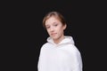 Portrait caucasian teenager in white sweatshirt with hood on black background. Royalty Free Stock Photo