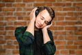 Portrait of a caucasian White young guy listen music in the ear-phones with eyes closed. Handsome man dressed in a black T-shirt Royalty Free Stock Photo