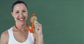 Portrait of caucasian woman holding medal around her neck smiling against green background Royalty Free Stock Photo