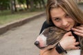 Portrait of caucasian woman hugging her bull terrier dog outdoors. Royalty Free Stock Photo