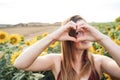 Portrait of Caucasian woman making a heart shape with her hands and fingers at sunflower field Royalty Free Stock Photo