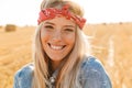 Portrait of caucasian woman 20s laughing and walking through golden field, during sunny day Royalty Free Stock Photo