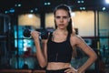 Portrait of Caucasian woman in sportswear lifting dumbbell in gym