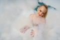 Portrait of caucasian woman in swimming suit in foam bubbles party