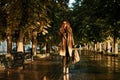 Portrait of caucasian woman using mobile phone while walking through empty boulevard Royalty Free Stock Photo