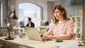 Portrait of Caucasian Young Inspired Woman Smiling and Working on Laptop in Busy Office. Analyst