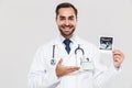 Portrait of caucasian young medical doctor working in hospital and holding ultrasound scan of baby Royalty Free Stock Photo