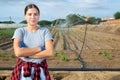 Portrait of woman agriculturist on field during irrigation