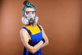 Portrait of Caucasian young woman builder. The arms are folded over the chest. Wearing protective goggles and a Royalty Free Stock Photo