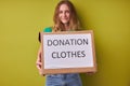 Portrait of caucasian young woman holding box donation clothes