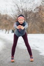 Young woman stretching and warming up for jogging outside in winter park Royalty Free Stock Photo