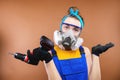 Portrait of a caucasian young woman in the uniform of a superintendent of streetwear in overalls, respirator and goggles Royalty Free Stock Photo