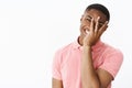 Portrait of charismatic happy good-looking bright african american guy holding palm on face peeking through fingers