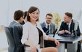 Portrait of a charismatic woman at a meeting while her team working in the background.