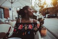 Black girl with the calabash and coctail in cafe outdoors