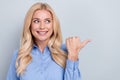 Portrait of charming attractive mature blond woman worker direct thumb finger look side mockup adv isolated grey color Royalty Free Stock Photo