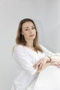 Portrait of Charming Beautician in White Lab Coat Looking at Camera With Smile, Near Couch