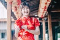 Portrait charming beautiful asian woman wear cheongsam dress gets red envelopes from her family. Pretty girl shows red envelopes. Royalty Free Stock Photo