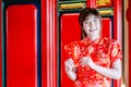 Portrait charming beautiful asian woman wear cheongsam dress gets red envelopes from her family. Pretty girl shows red envelopes. Royalty Free Stock Photo